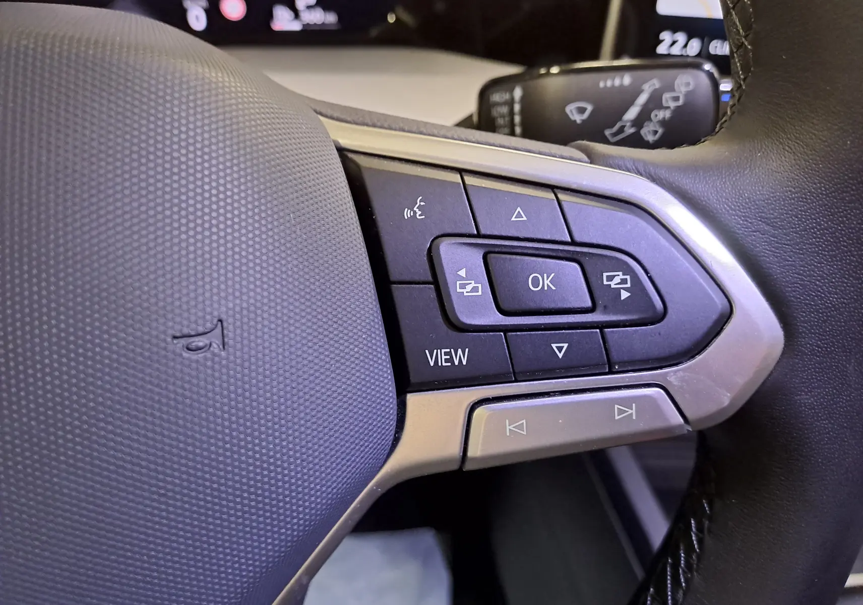 Gros plan sur les commandes multifonctions à droite du volant noir de la Volkswagen Golf 1.5 eTSI 2025.