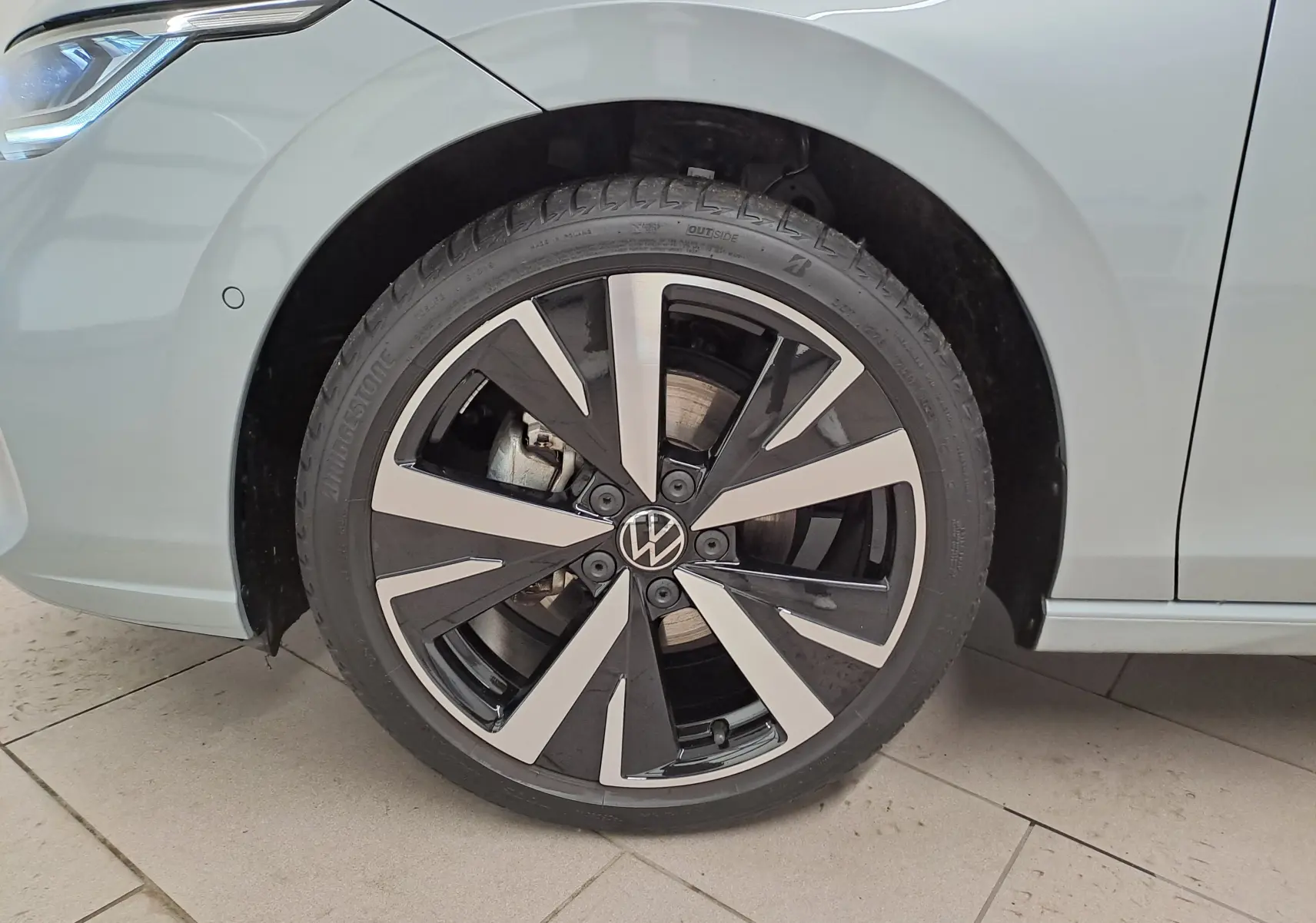 Gros plan sur la roue avant gauche de la Volkswagen Golf 1.5 eTSI 2025 en Argent Dolomite avec jante alliage 18'' Catania.