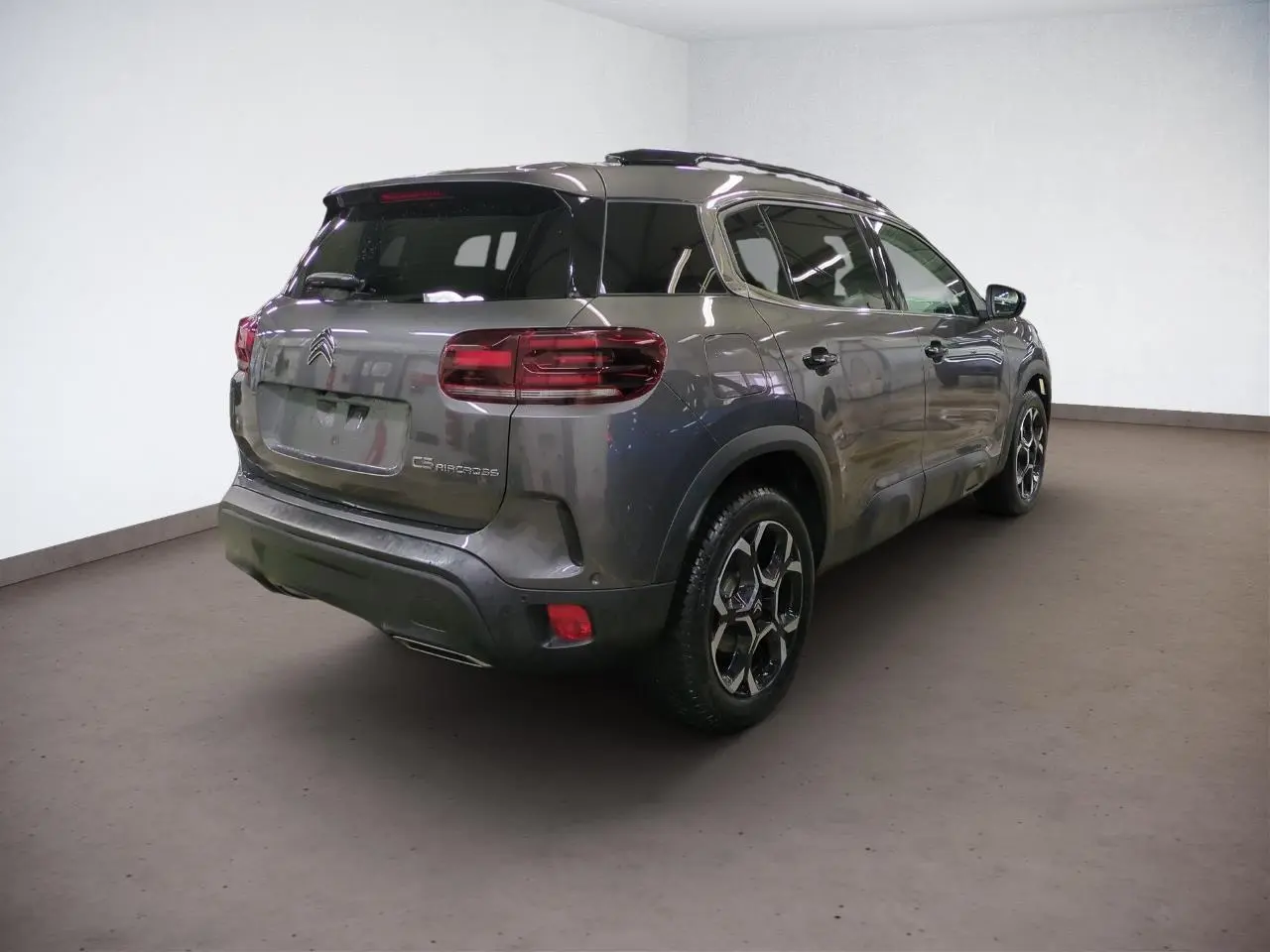 Vue 3/4 arrière droit d'un Citroën C5 Aircross Hybrid gris Platinium avec jantes alliage et hayon électrique.