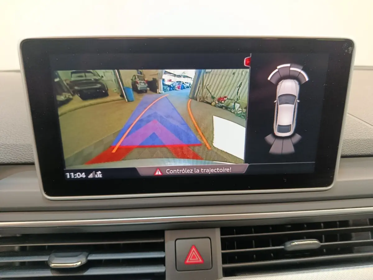 Affichage écran intérieur montrant la caméra de recul et l'aide au stationnement de l'Audi A5 gris clair 2019.