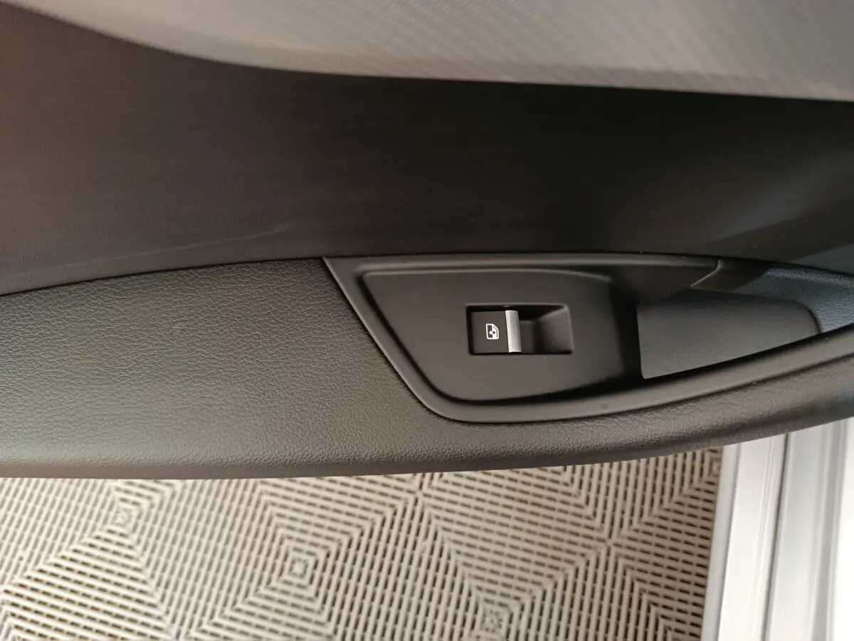 Bouton de verrouillage des portes sur la garniture intérieure noire de la porte côté conducteur d'une Audi A5 gris clair.