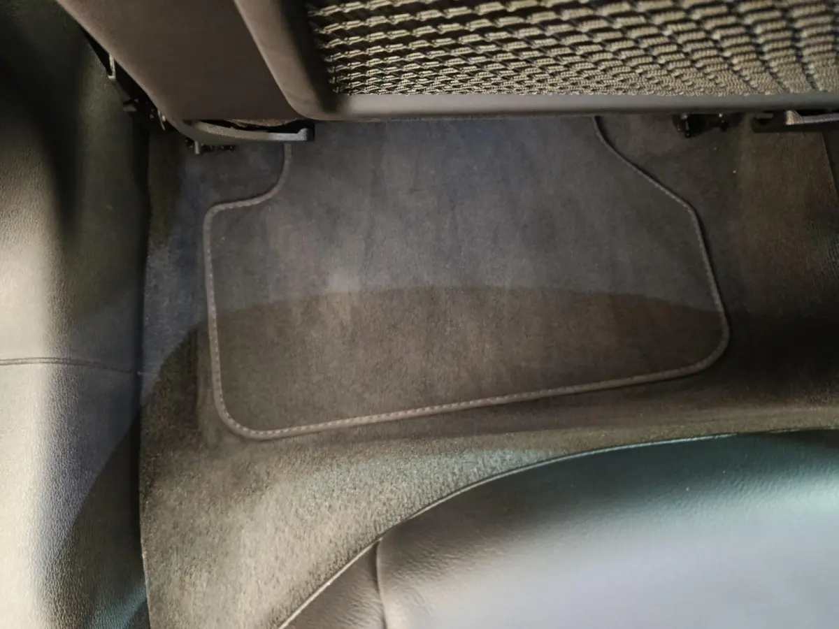 Vue rapprochée du sol et tapis noir côté passager arrière d’une Audi A5 gris clair 2019.