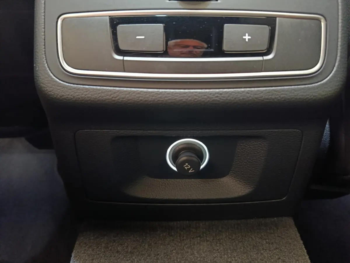 Prise 12V en gros plan sur la console arrière noire de l'Audi A5 40 TFSI 2019, intérieur sombre.