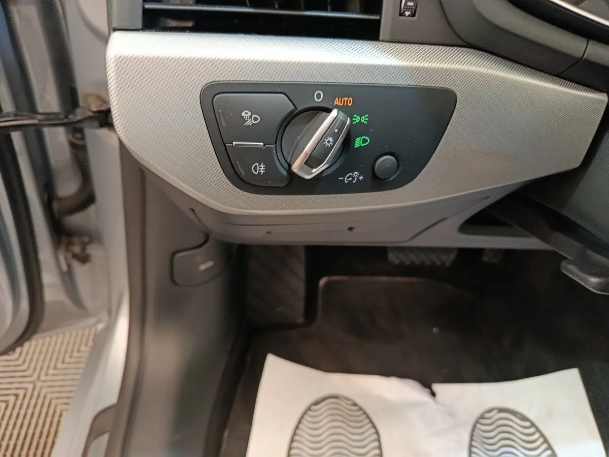 Gros plan sur le panneau de commande des phares à gauche, intérieur gris clair de l'Audi A5 2019.