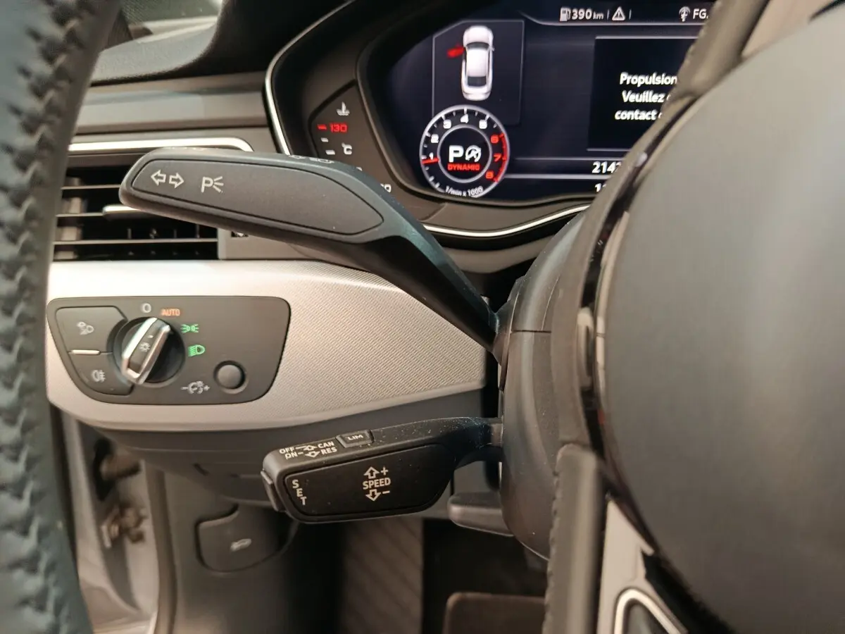 Gros plan sur le volant et le tableau de bord digital noir et gris clair de l'Audi A5 40 TFSI, avec commandes au volant visibles.
