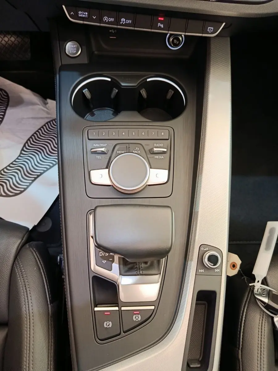 Vue plongeante sur la console centrale noire et argentée de l'Audi A5 2019 avec commandes multimédia et levier de vitesse.