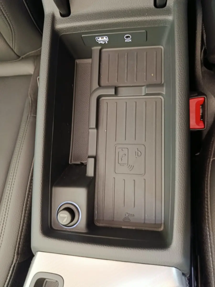 Vue rapprochée de la console centrale noire de l'Audi A5 2019, avec prise USB, AUX et chargeur sans fil.
