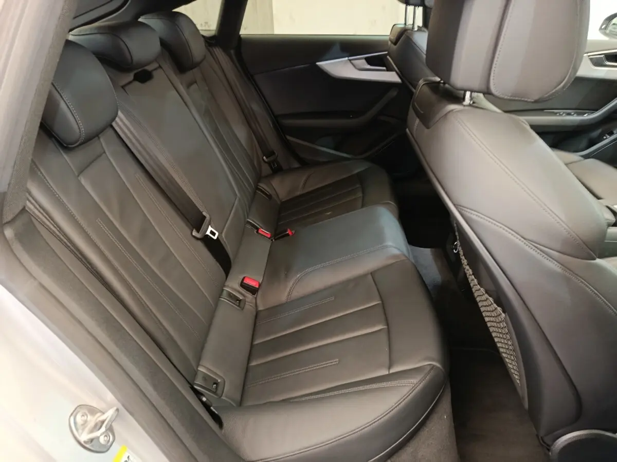 Vue intérieure côté arrière droit de l'Audi A5 2019 avec sièges en cuir noir et finitions élégantes.