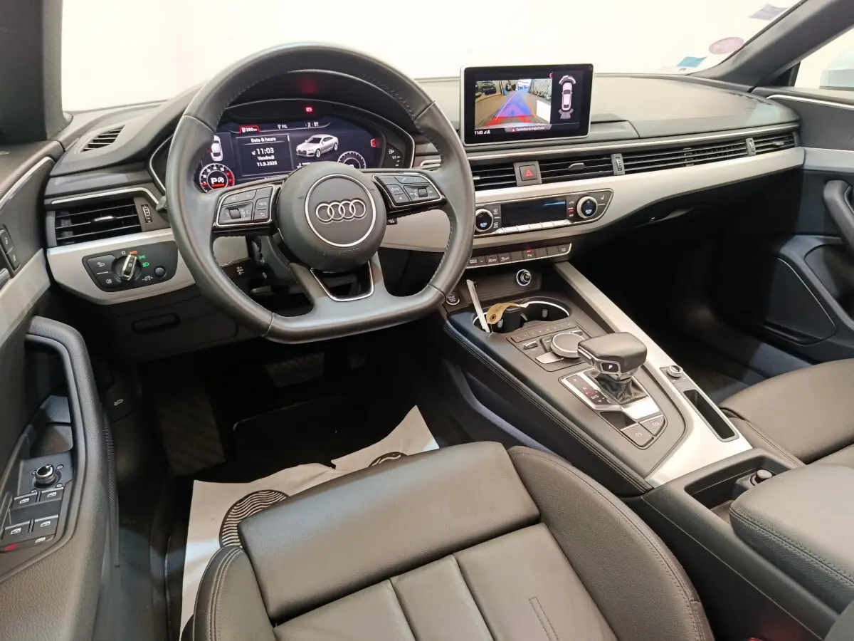 Vue intérieure de l'Audi A5 40 TFSI 2019, tableau de bord moderne avec écran multimédia et volant cuir noir.