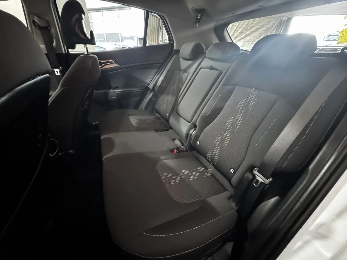 Vue intérieure côté droit des sièges arrière noirs du Kia Sportage 2024 avec ceinture de sécurité visible.
