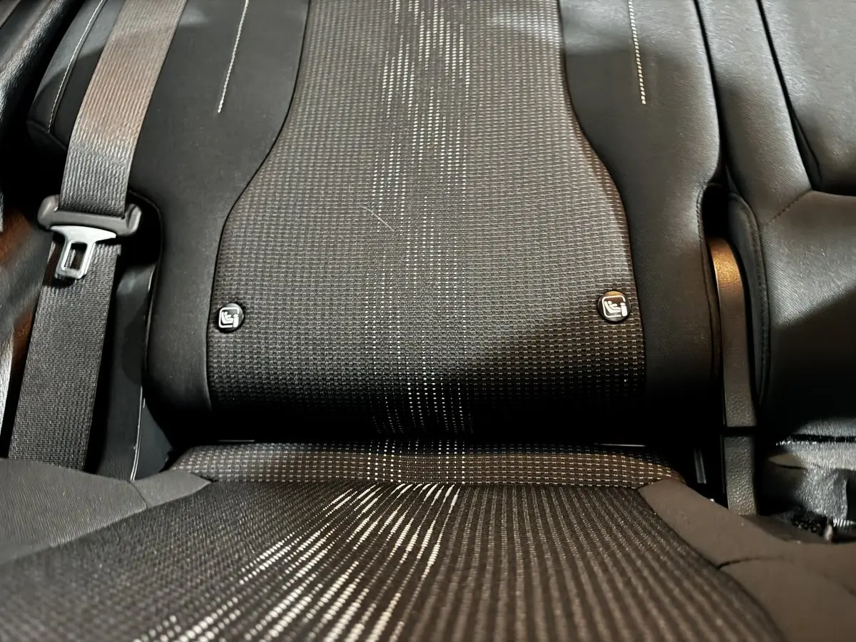 Gros plan sur la banquette arrière noire du Kia Sportage 2024, avec ceintures et fixations Isofix visibles.