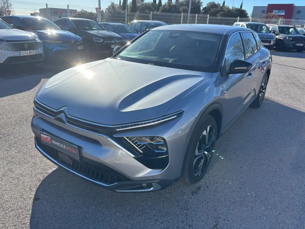Citroën C5 X gris foncé vue 3/4 avant droit, avec jantes alliage 19 pouces et barres de toit visibles.