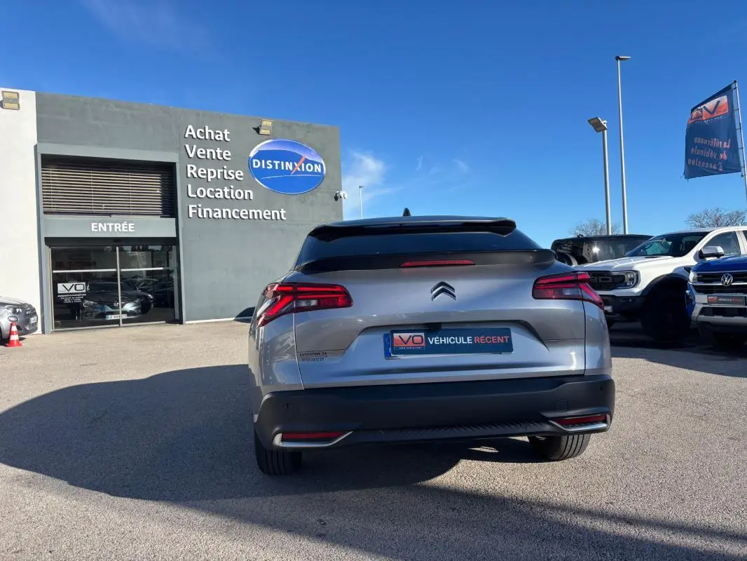 Vue arrière d'une Citroën C5 X gris foncé 2024 avec feux LED et jantes alliage 19 pouces, stationnée en extérieur.