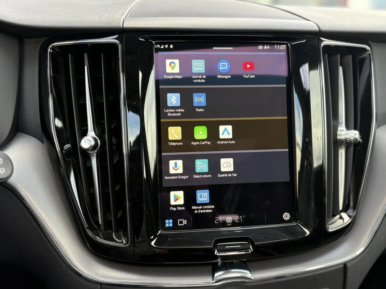 Écran tactile central du tableau de bord du Volvo XC60 2024 gris Silver, avec commandes multimédia et aérateurs verticaux.