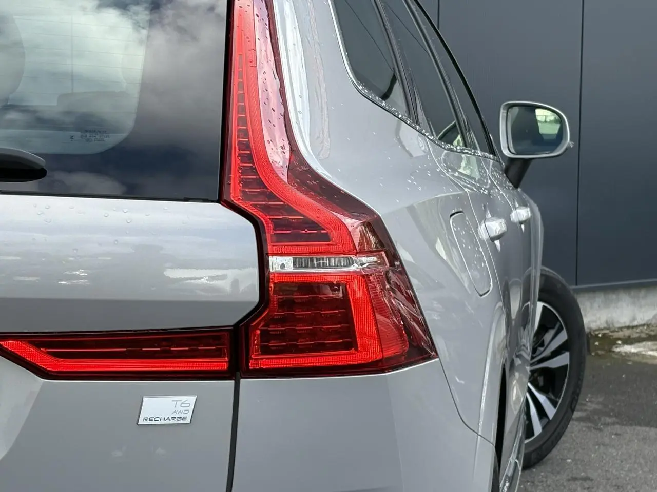 Vue arrière droite du Volvo XC60 T6 AWD PHEV gris silver, mettant en valeur les feux arrière LED et la jante alliage.