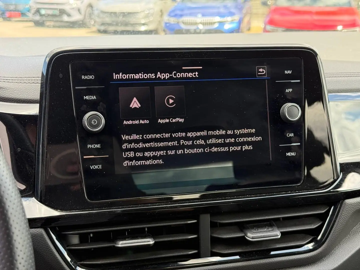Écran tactile central du Volkswagen T-Roc 2025 affichant la fonction App-Connect, entouré de commandes noires brillantes.