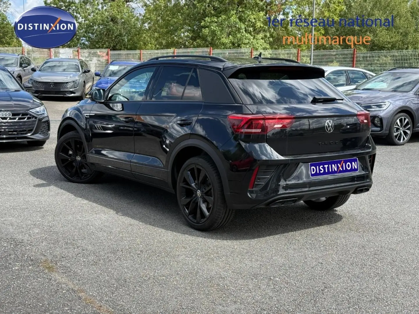 Volkswagen T-Roc noir nacré en 3/4 arrière droit, avec jantes noires et vitres arrière surteintées.
