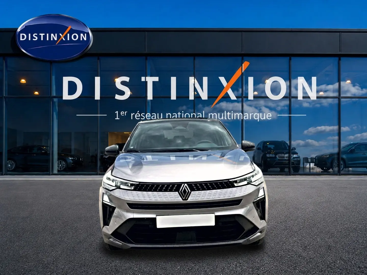 Vue avant d'un Renault Captur 2026 cassiope toit noir, avec calandre moderne et phares LED fins, devant un showroom Distinxion.