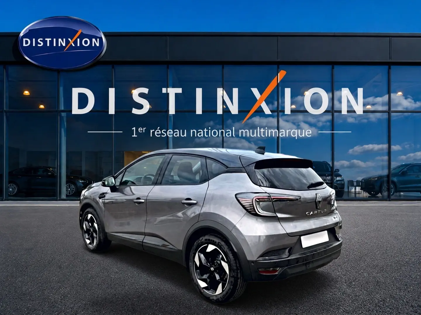 Renault Captur 1.8 e-tech hybride 2026 gris Cassiope toit noir, vue 3/4 arrière côté gauche, jantes alu distinctives.