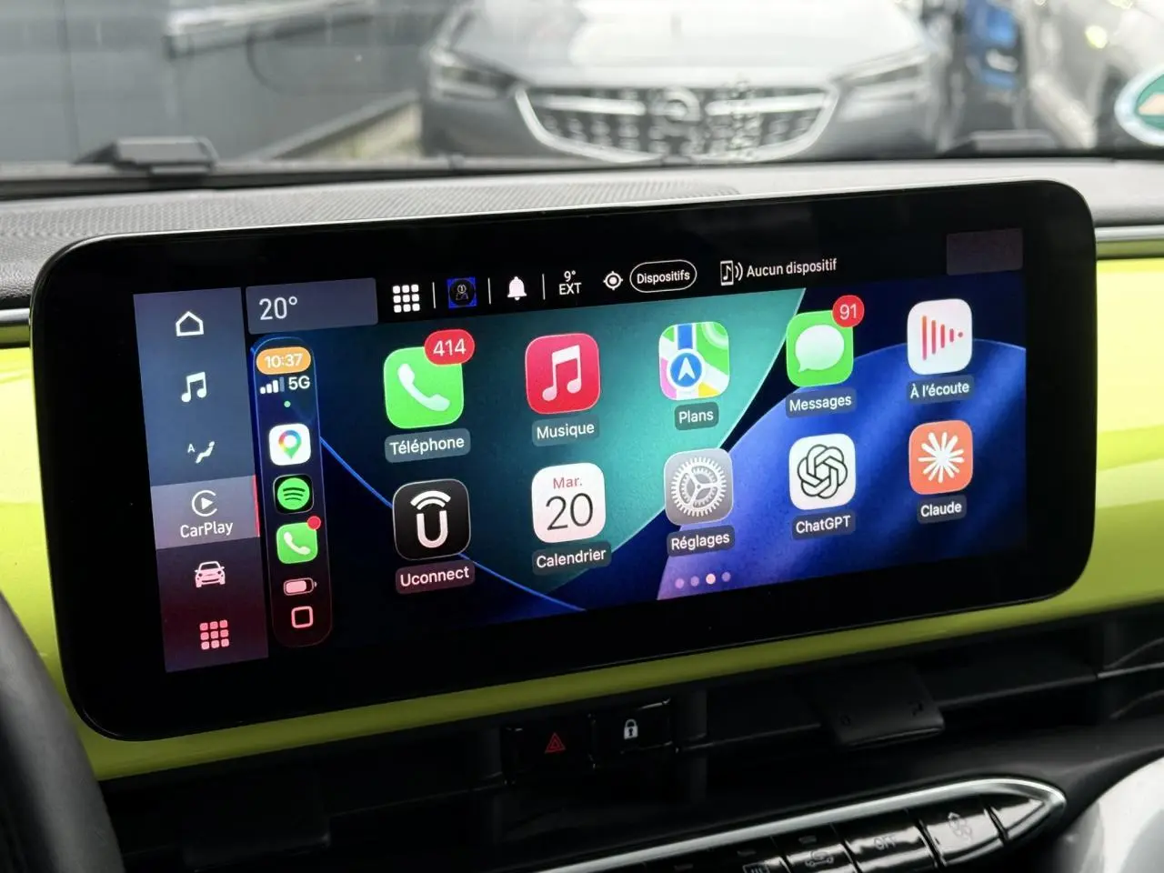 Écran tactile central de la Fiat 500 électrique jaune Acid, affichant l'interface Apple CarPlay avec plusieurs applications.