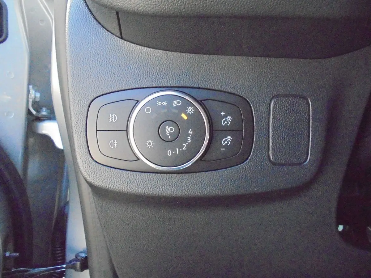 Gros plan sur la commande d'éclairage intérieure noire du Ford Puma 2022, côté gauche du tableau de bord.