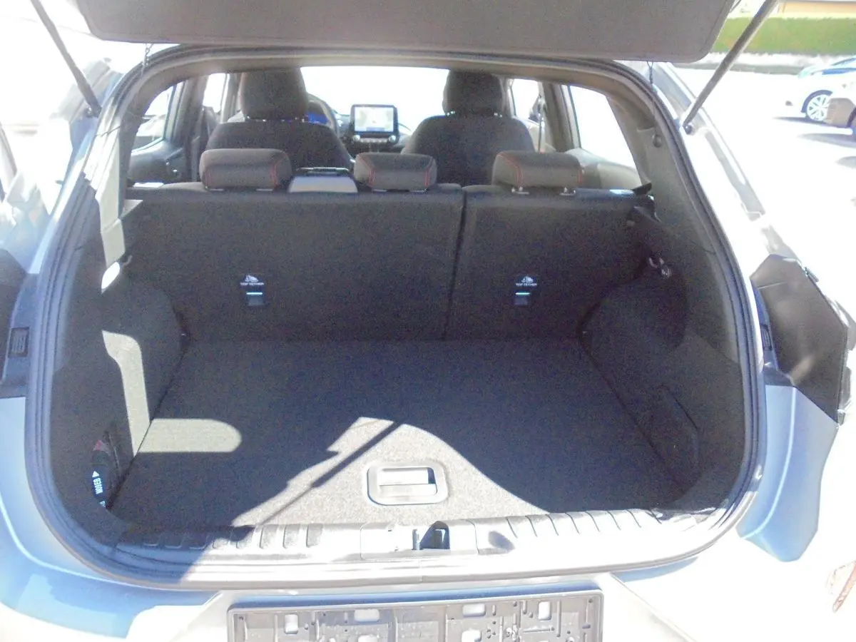 Coffre ouvert vu de l'arrière d'un Ford Puma gris Solar Metal, montrant l'espace de chargement et les sièges arrière.