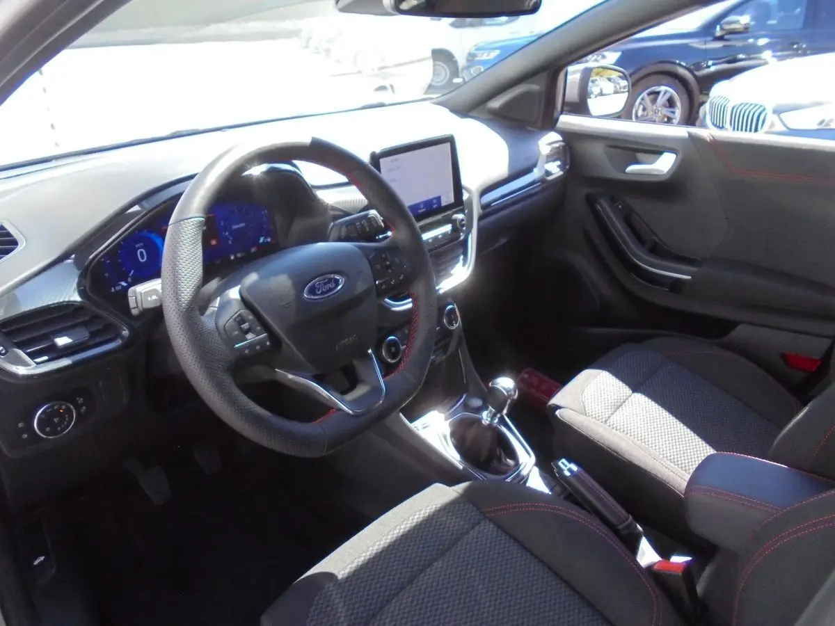 Intérieur avant droit du Ford Puma gris Solar Metal 2022, volant cuir perforé, tableau de bord digital et boîte manuelle.