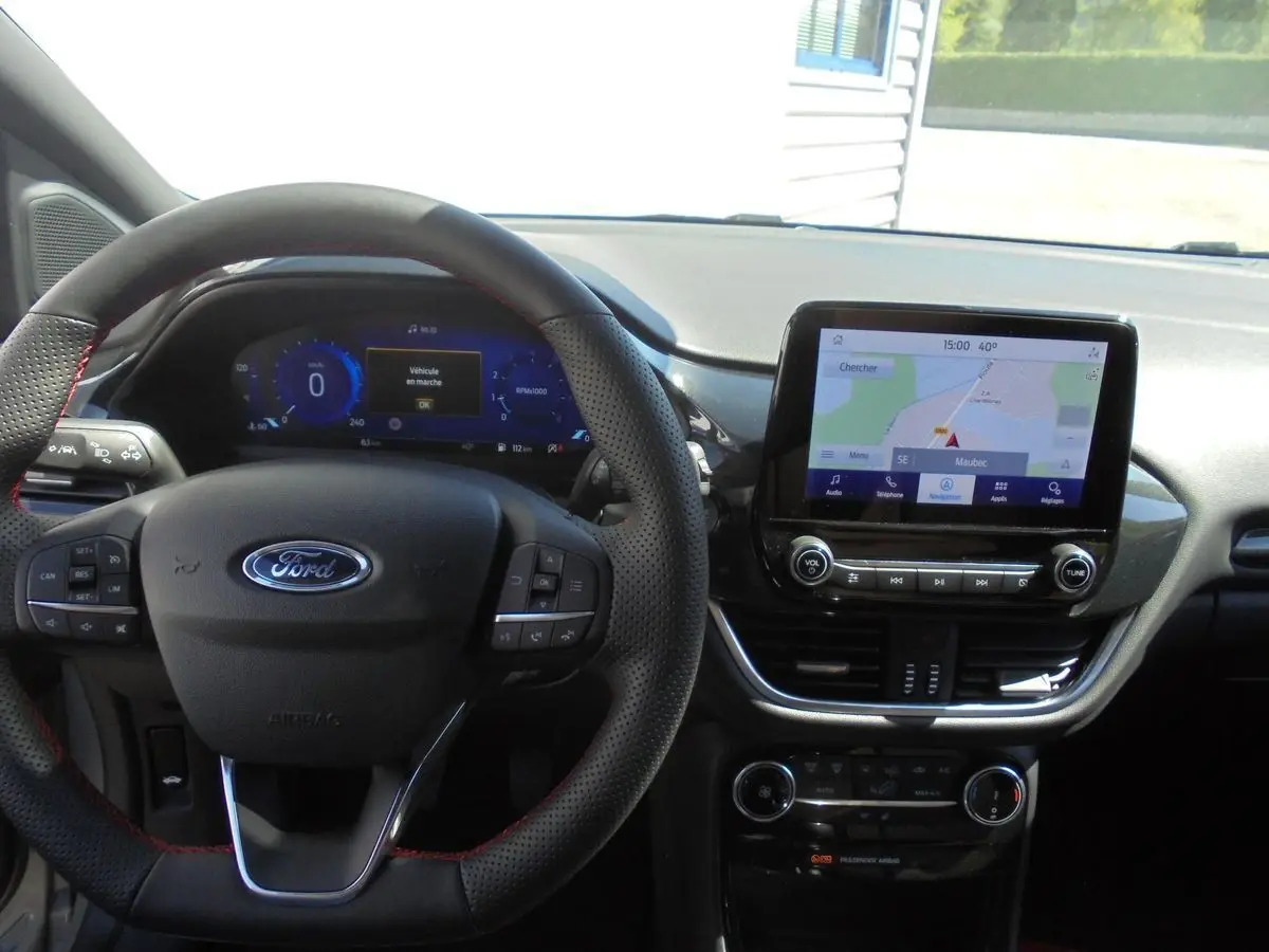Vue intérieure du tableau de bord du Ford Puma 2022, avec volant noir perforé et écran tactile de navigation allumé.