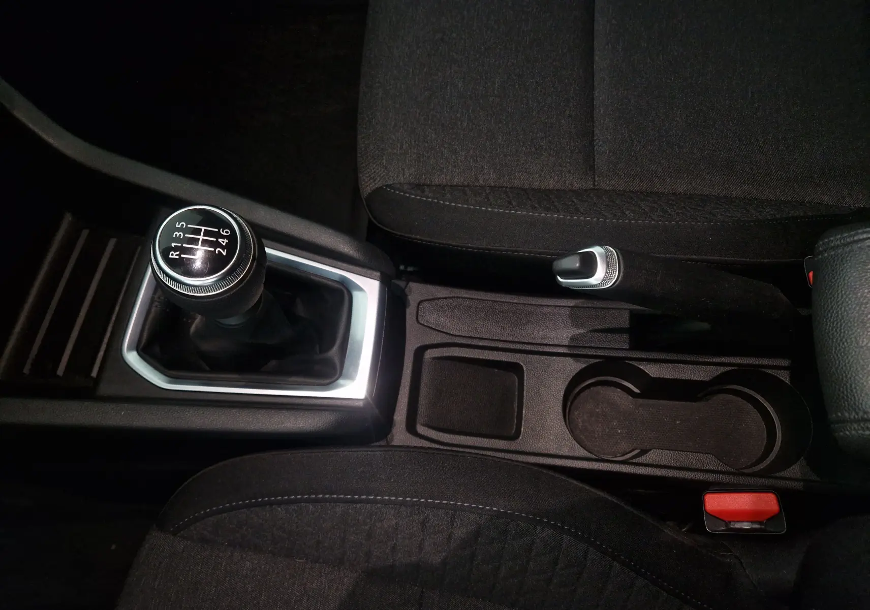 Vue rapprochée de la console centrale de la Renault Clio V gris platine, avec levier de vitesse manuel et frein à main.