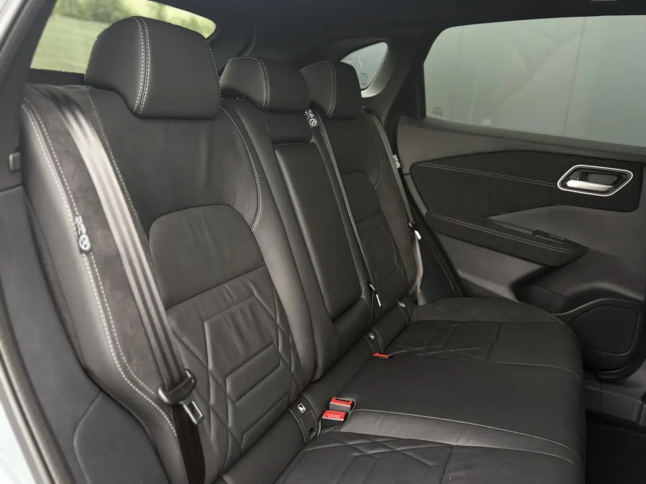 Vue latérale des sièges arrière en cuir noir avec surpiqûres blanches du Nissan Qashqai 2025 NV 1.5 e-Power N-Design.