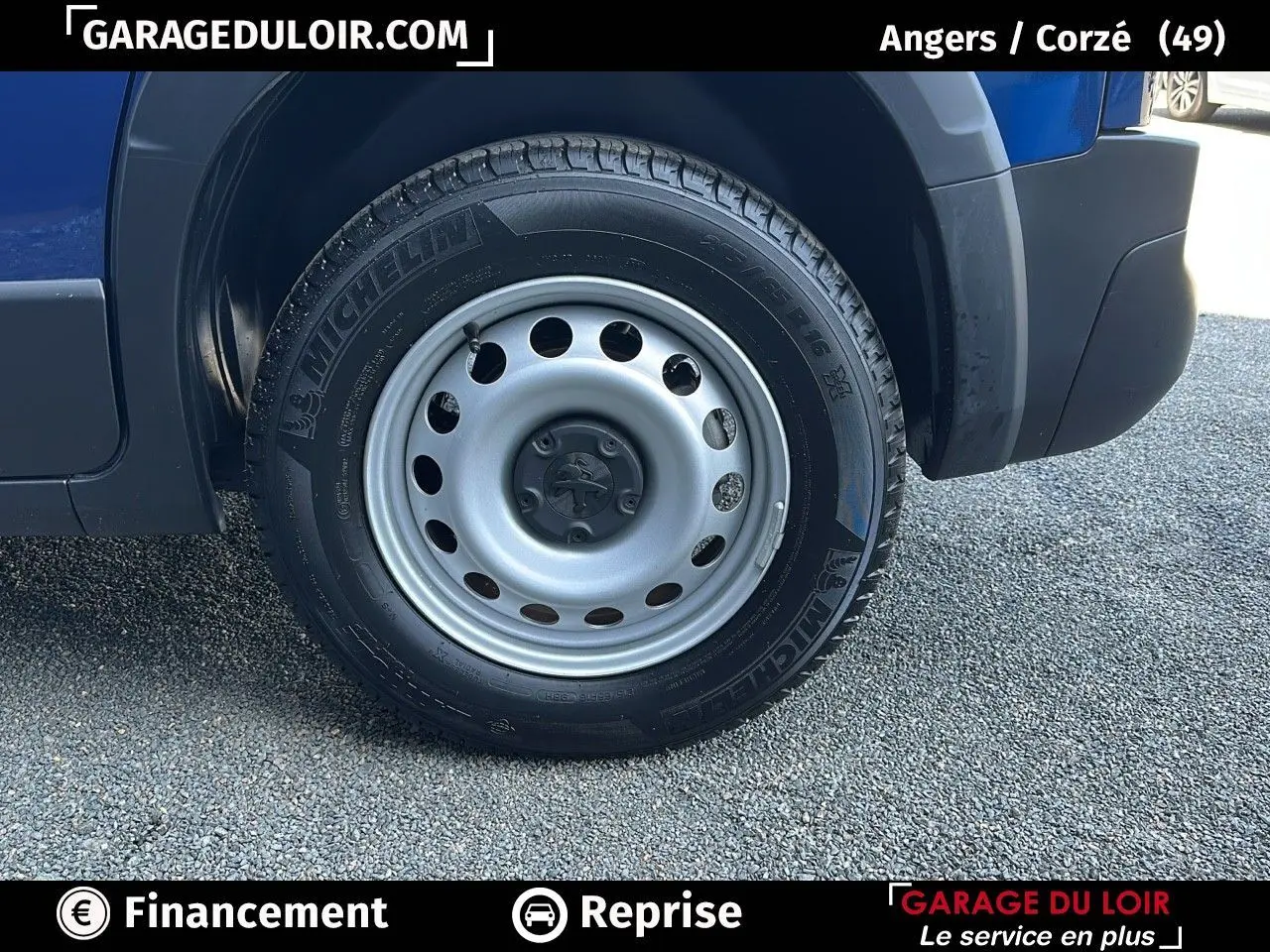 Gros plan sur la roue avant droite en jante tôle grise du Peugeot Rifter bleu 2024, avec logo lion au centre.