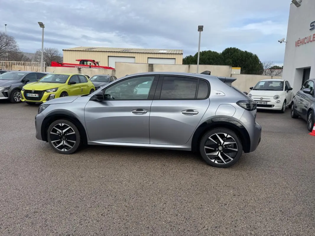 Peugeot 208 Hybrid 110 GT gris en vue profil droit, avec jantes alliage 17 pouces et toit noir contrasté.