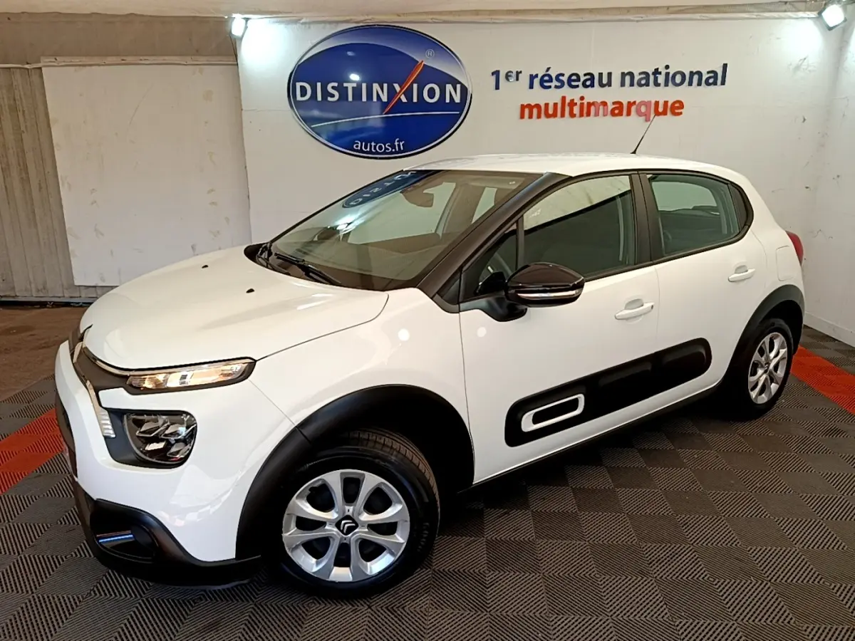 Citroën C3 blanche vue 3/4 avant droit avec protections latérales noires et jantes alliage.