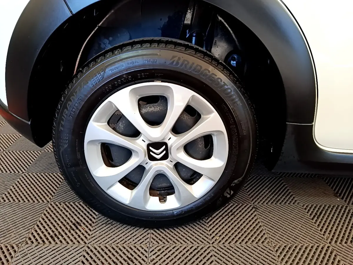 Gros plan sur la roue avant gauche blanche d'une Citroën C3 2022 avec jante en alliage et pneu Bridgestone.