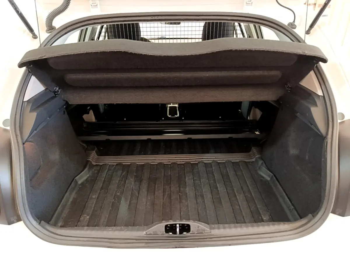Vue arrière du coffre ouvert d'une Citroën C3 blanche, montrant l'espace de chargement et la tablette cache-bagages relevée.