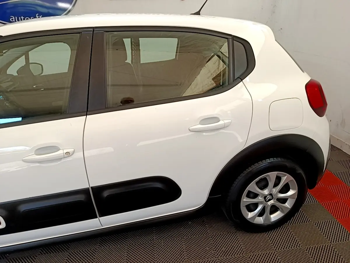 Vue latérale droite d'une Citroën C3 blanche avec protections noires sur les portières et jantes argentées.