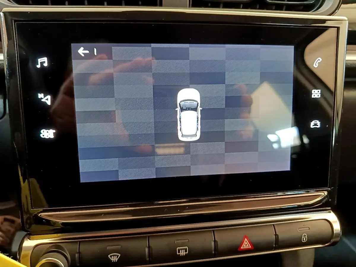 Écran tactile intérieur affichant la vue aérienne de la Citroën C3 blanche, tableau de bord en arrière-plan.