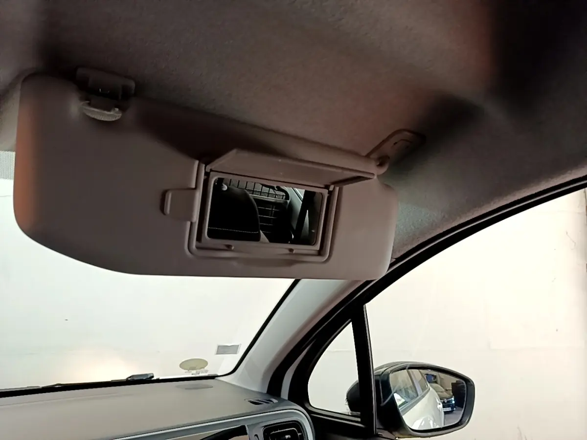Miroir de courtoisie ouvert côté conducteur dans l’habitacle d’une Citroën C3 blanche vue de l’intérieur avant droit.