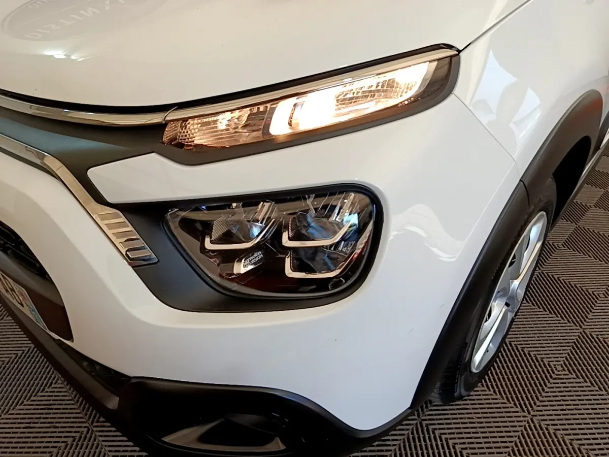 Gros plan sur l'avant droit blanc de la Citroën C3 2022 avec phares LED et détails noirs contrastants.