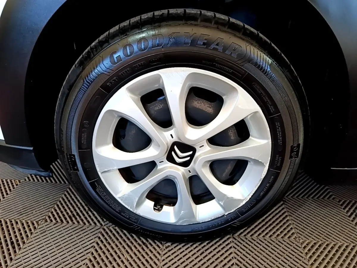 Gros plan sur la jante alliage argentée et le pneu Goodyear d'une Citroën C3 blanche, côté droit.