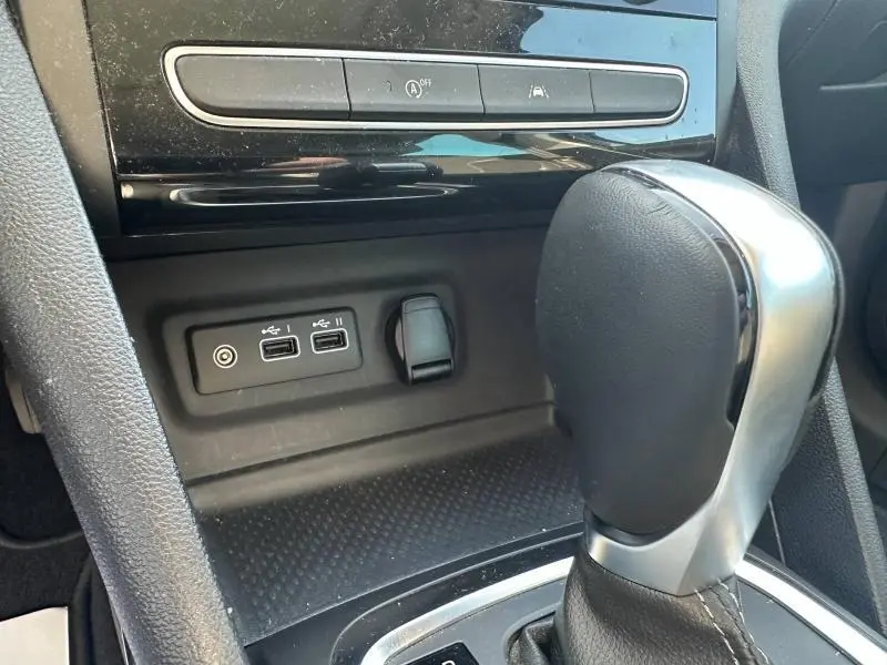 Gros plan sur la console centrale noire de la Renault Mégane Break 2024, avec levier de boîte auto et ports USB visibles.