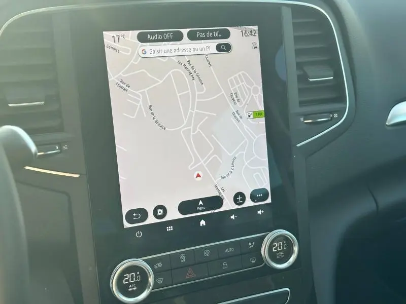 Vue rapprochée de l'écran tactile central avec navigation GPS dans l'habitacle gris d'une Renault Mégane Break 2024.
