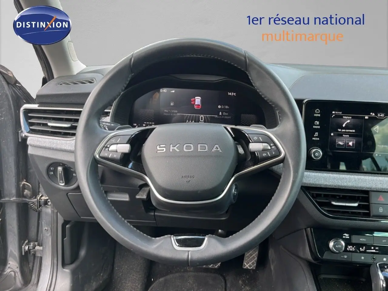 Vue intérieure centrée sur le volant cuir de la Skoda Scala gris magnétique, avec tableau de bord digital et écran tactile.