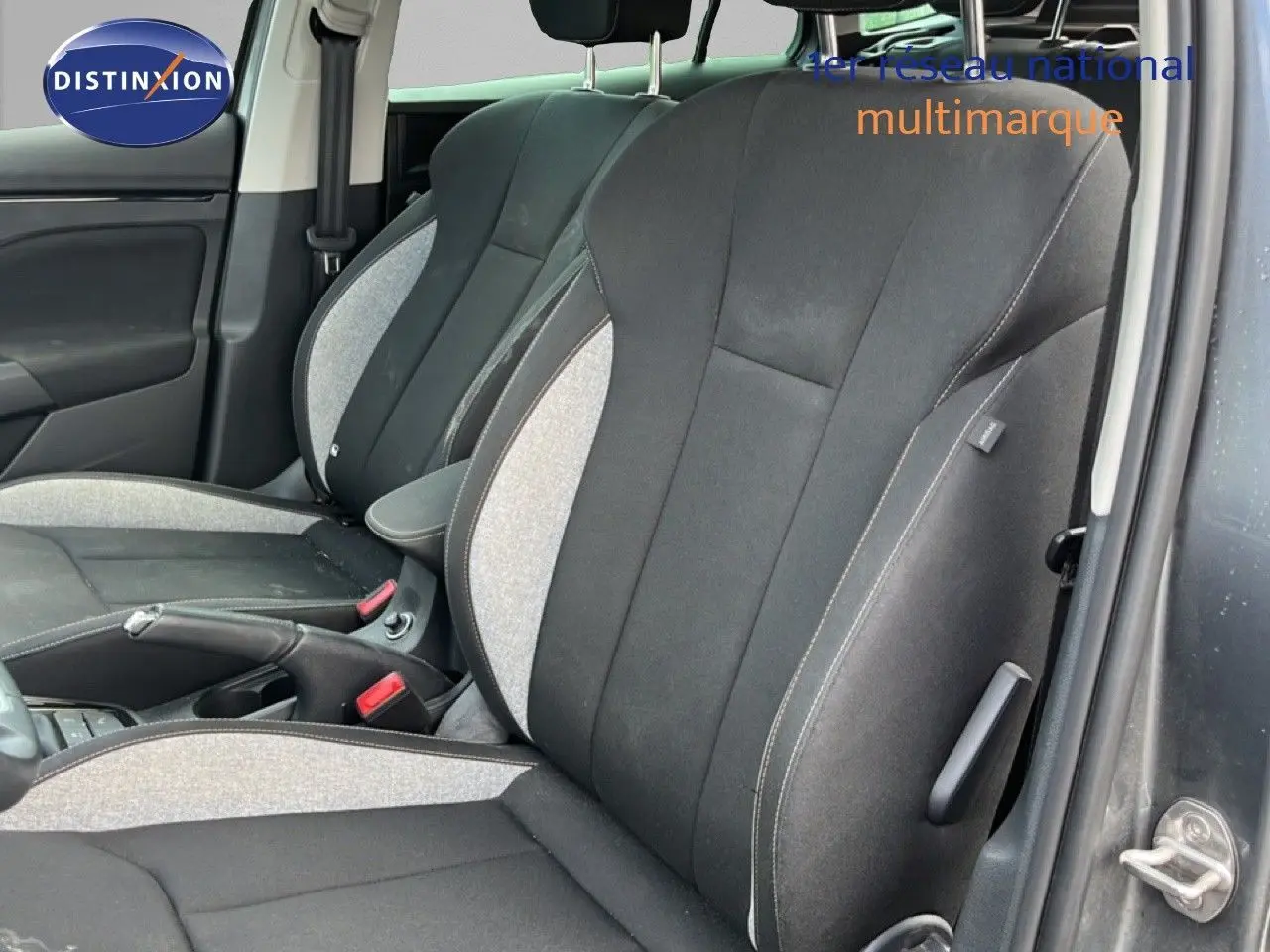 Vue intérieure sur les sièges avant tissu gris et noir d'une Skoda Scala 2025, avec accoudoir central visible.