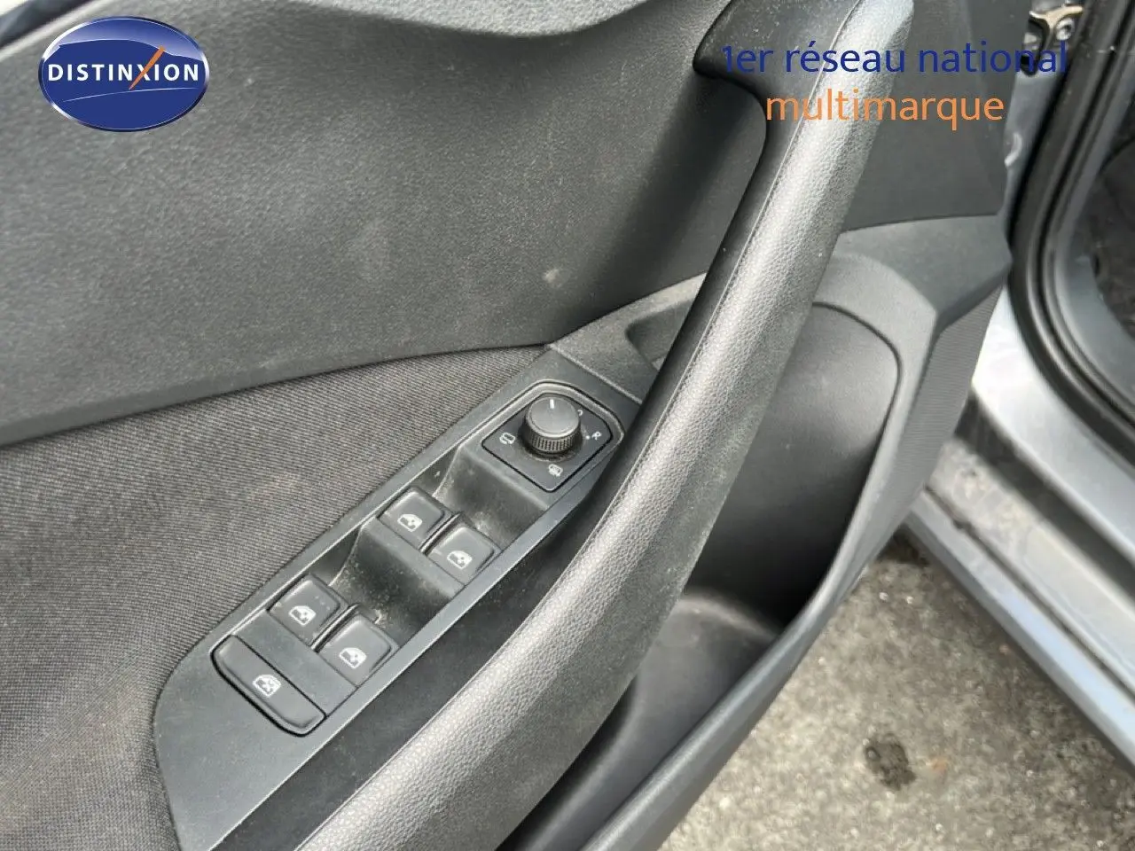 Détail de la commande des vitres électriques sur la porte côté conducteur d'une Skoda Scala gris magnétique 2025.