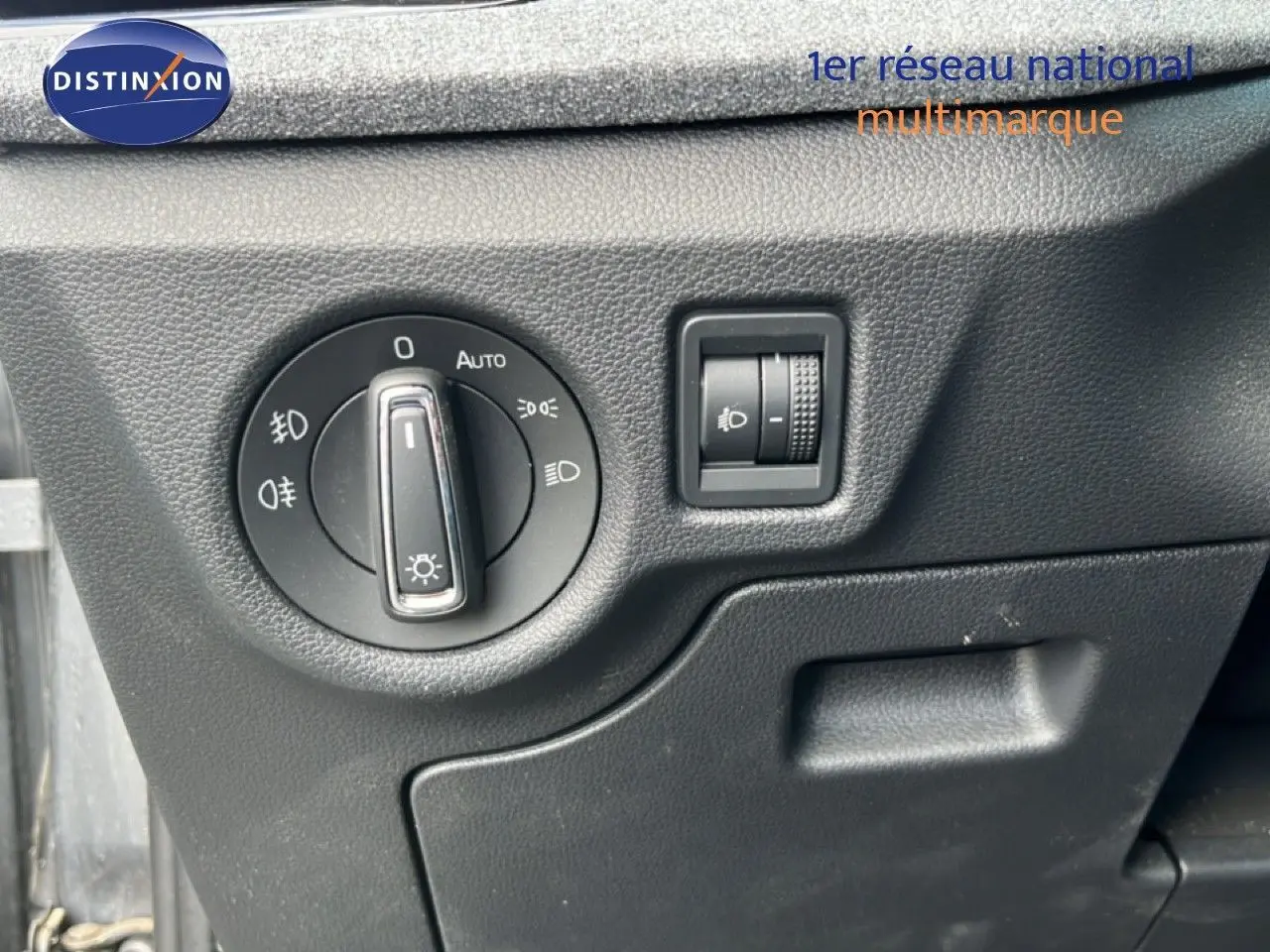 Gros plan sur le tableau de bord noir de la Skoda Scala 2025 montrant la commande des phares et le réglage de hauteur.