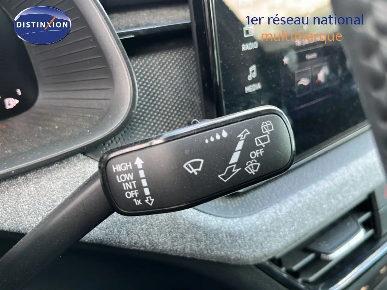 Gros plan sur la commande d’essuie-glace de la Skoda Scala 2025, intérieur gris métallique avec écran tactile visible.