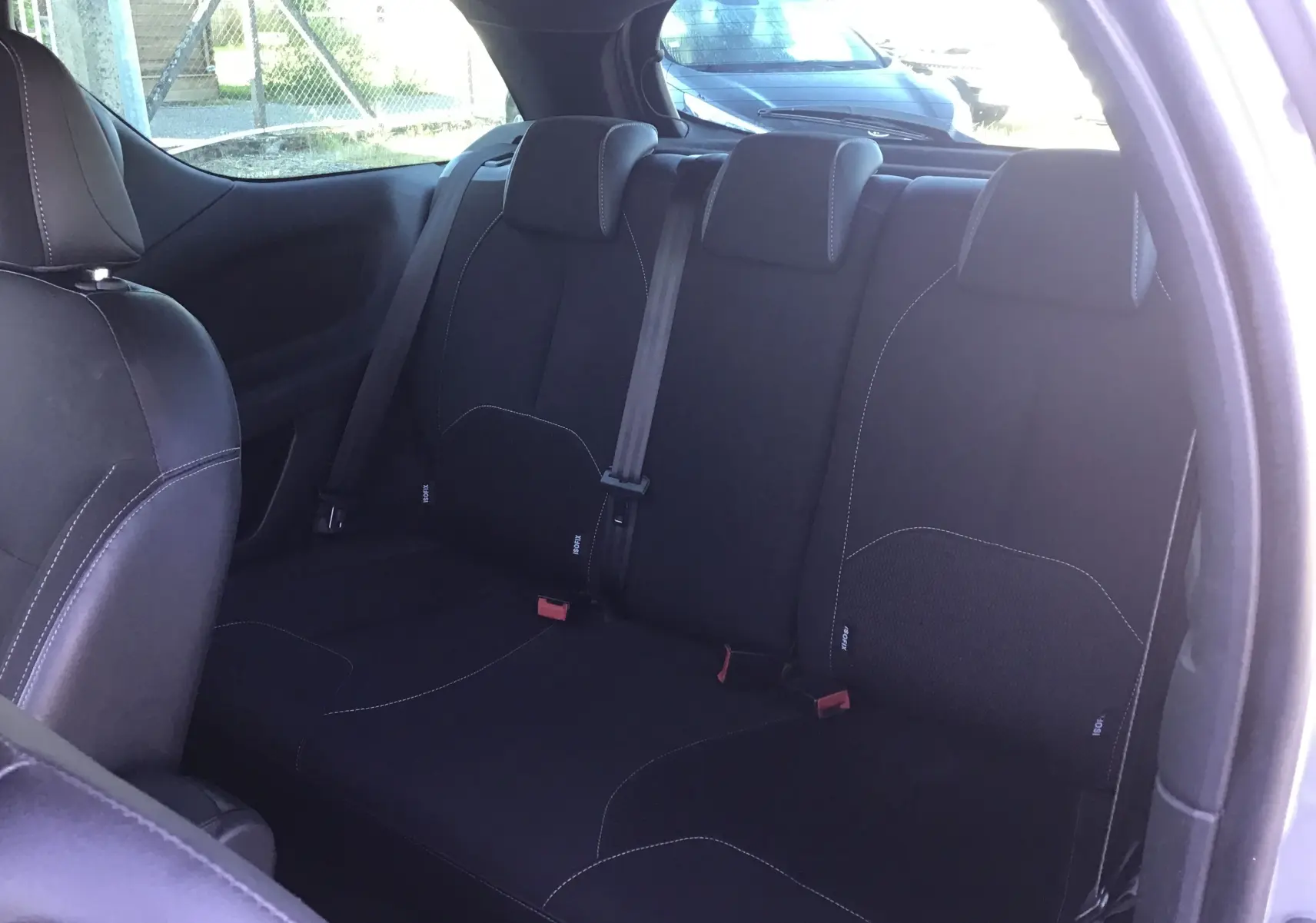 Vue intérieure arrière montrant les sièges noirs avec surpiqûres blanches de la Citroën DS3 2013, version 1.6 HDI SO CHIC.