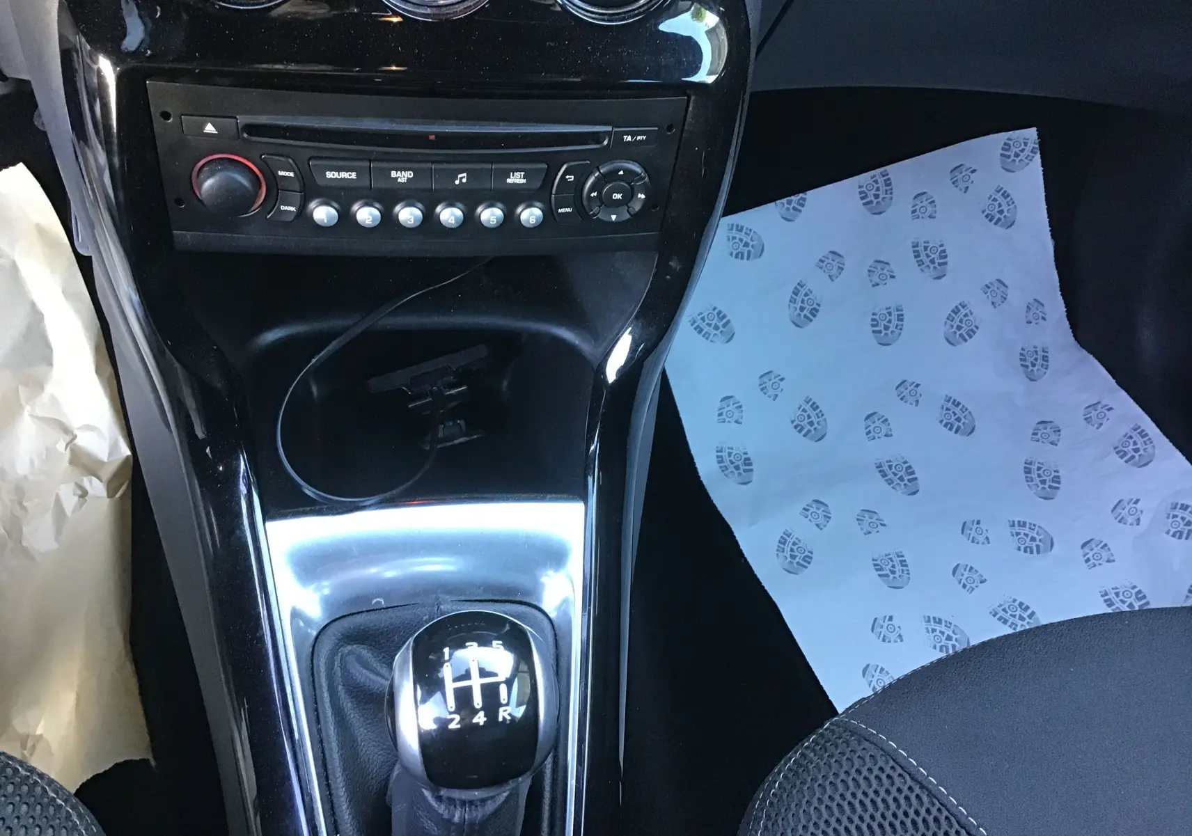Vue rapprochée de la console centrale d'une Citroën DS3 gris clair, mettant en valeur le levier de vitesse manuel et la radio.