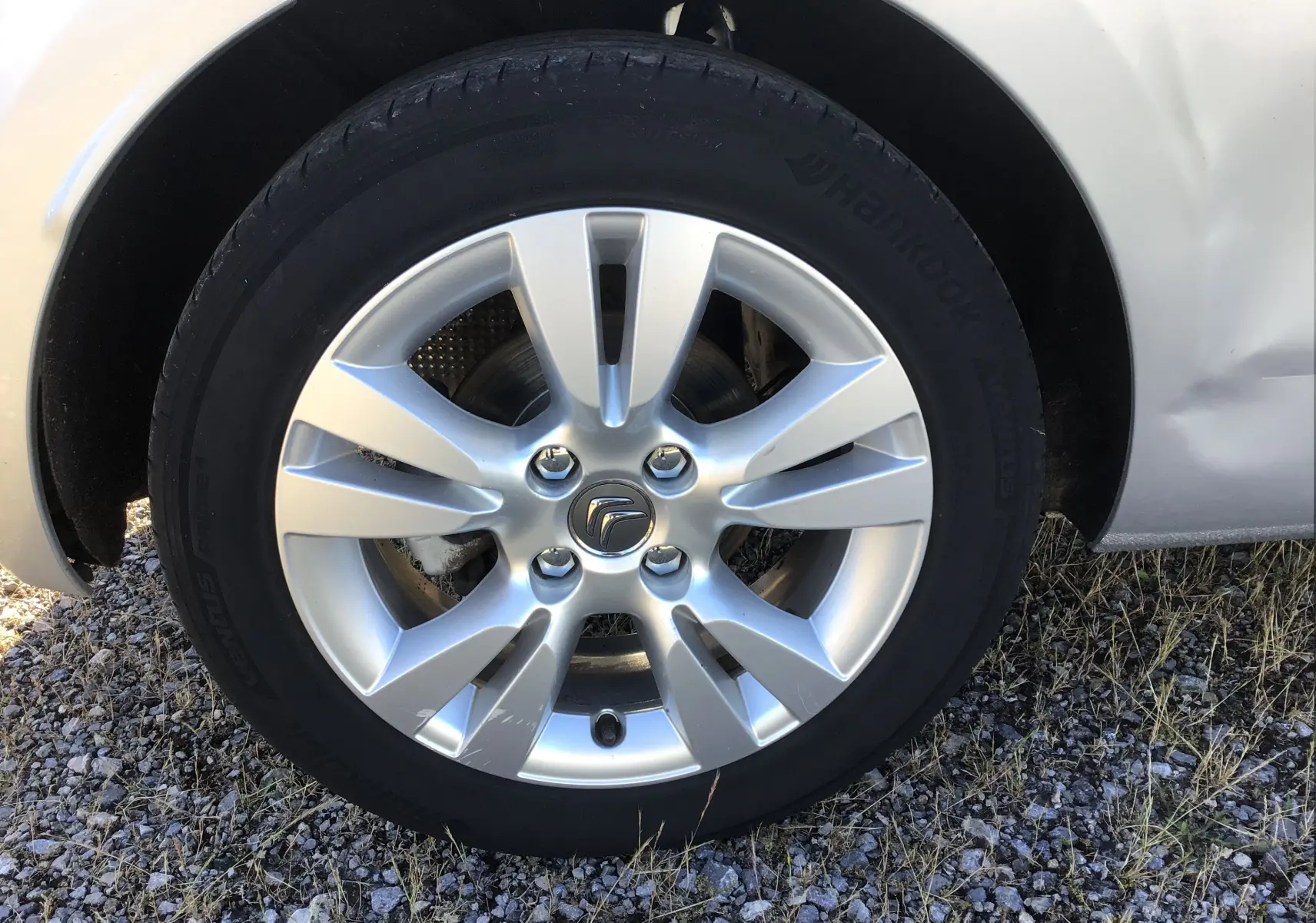 Gros plan sur la roue avant droite d'une Citroën DS3 gris clair métal avec jante alliage 16 pouces et logo Citroën central.